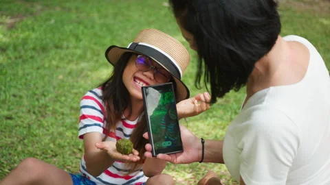 Child showing nature find while mother takes photo with smartphone Stock Footage 306745530