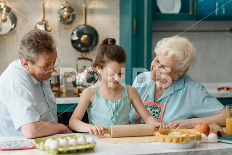 Child shows her cooking skills. Family in the kitchen Stock Photos