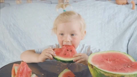The child sits and eats sweet watermelon with pleasure. Stock Footage 133833914
