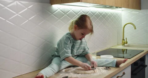 Child sits kitchen counter, rolling dough Vídeo Stock 333523785