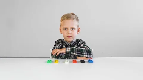 The child sits motionless at a white table with plasticine Stock Footage 124941746