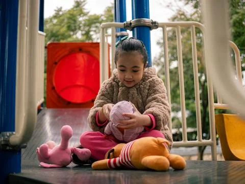 Child sits on a playground slide Stock Photos