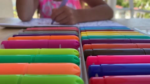 A child sits at a table and enthusiastically draws, paints with colorful felt Stock Footage 135142087