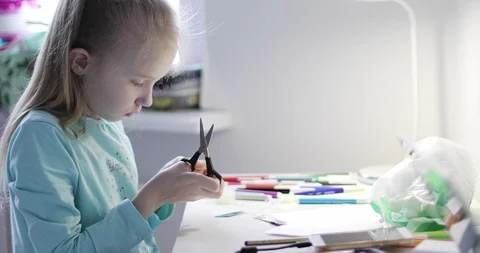 The child sits at the table and makes crafts. Hobby. Stock Footage 110700460