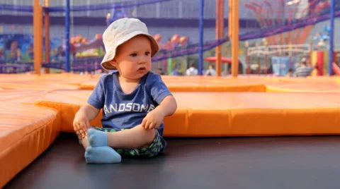 The Child Sits on a Trampoline Stock Footage 64764207