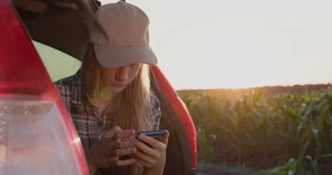 Child sits in the trunk of a car, uses a smartphone. Stock Footage 246748628
