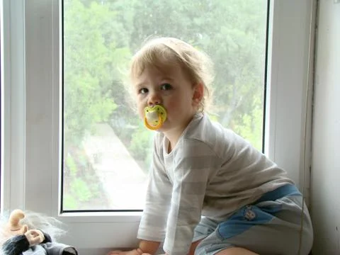 The child sits on the window Foto stock