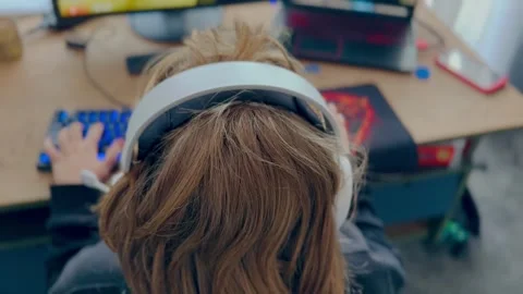 Child sitting at computer desk and playing game Stock Footage 282356786