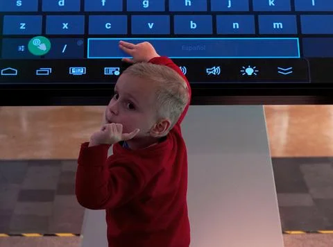 The child is sitting at the computer Stock Photos