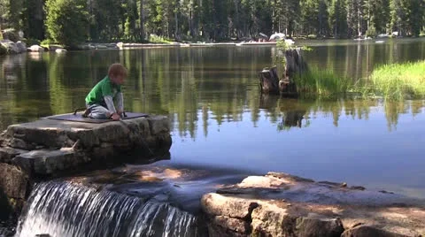 Child sitting on dam Stock Footage 25852968