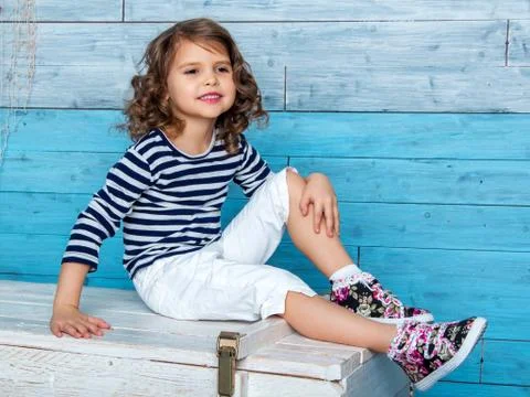 Child sitting on the dower chest Stock Photos
