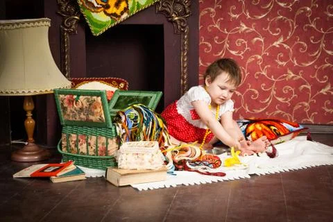 Child sitting by fireplace with thread Stock Photos