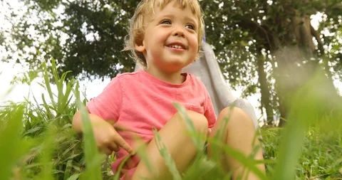 Child sitting in grass Stock Footage 100167326