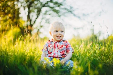 Child sitting on the grass Stock Photos