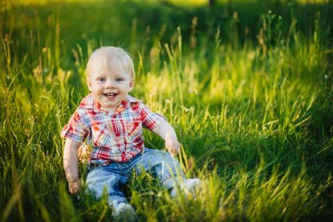 Child sitting on the grass Stock Photos
