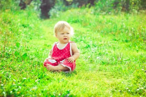 The child is sitting on the grass Stock Photos