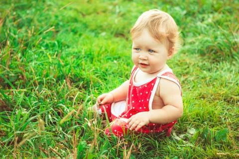 The child is sitting on the grass Stock Photos