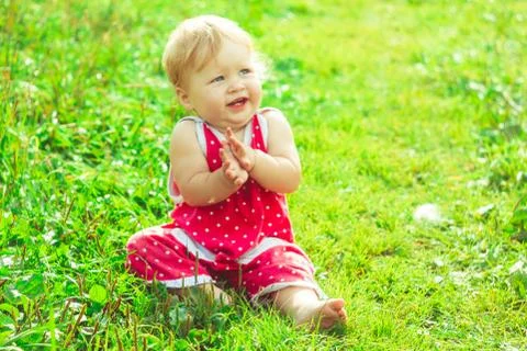 The child is sitting on the grass 库存照片