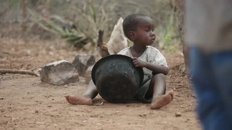 Child sitting on the grounds eating from pot. 動画素材 59796180
