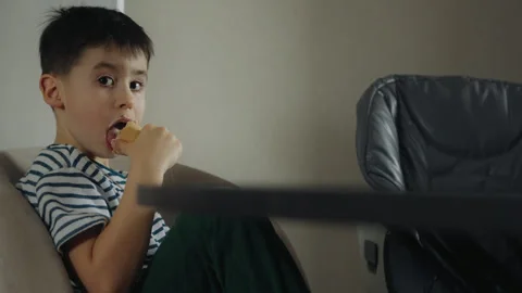 A child sitting in a high chair, snacking and sharing with a thumb gesture Stock Footage 274673744
