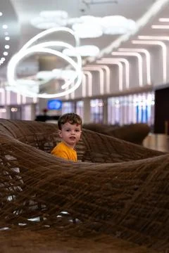 Child sitting in a lobby on a sofa during a relaxed family outing on Phu Qu.. Stock Photos