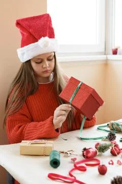 Child sitting in red pullover package red gift box closing. Stock Photos