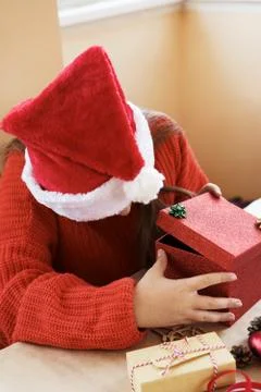 Child sitting in red pullover package red gift box opening Stock Photos