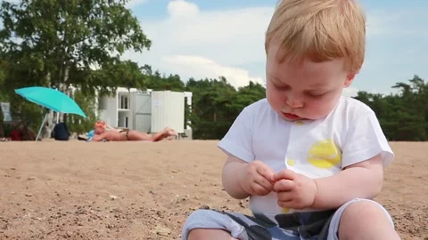 Child sitting on the sand Video stock 135733026
