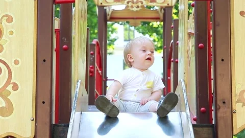 The child is sitting on the slide Video stock 133632067
