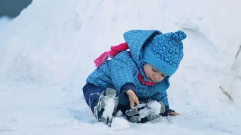 Child sitting in the snow Stock Footage 71950139
