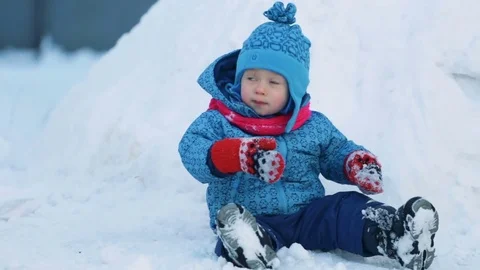 Child sitting in the snow Stock Footage 71950562