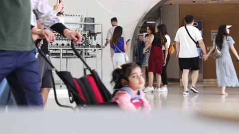 Child sitting in a stroller in a building Stock Footage 239410224