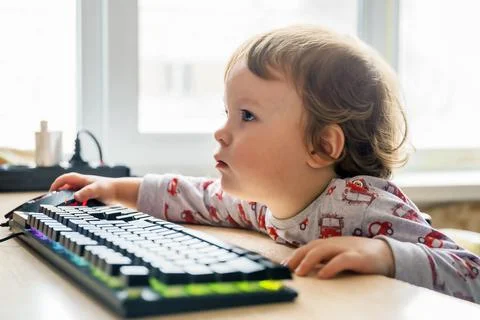 Child is sitting at the table and learning computer technology 스톡 사진