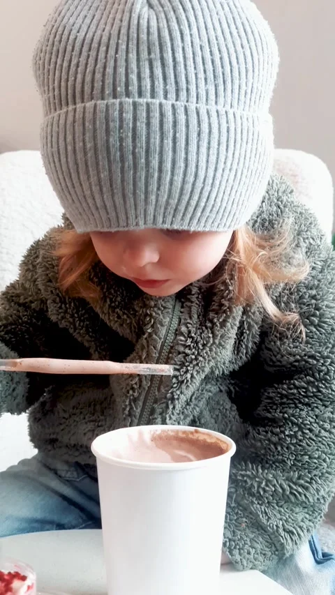 Child Sitting at Table Drinking Cocoa and Eating Cake Stock-Footage 332656735
