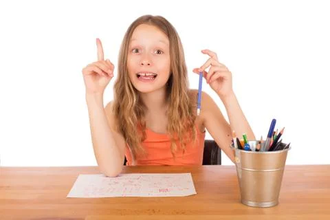 Child sitting at a table found an idea to draw Stock Photos