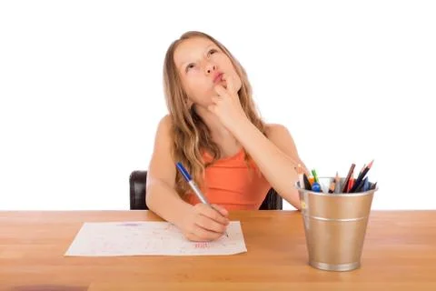 Child sitting at a table trying to make a drawing Stock Photos