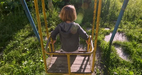 Child sitting in yard on old swing Video stock 112601351