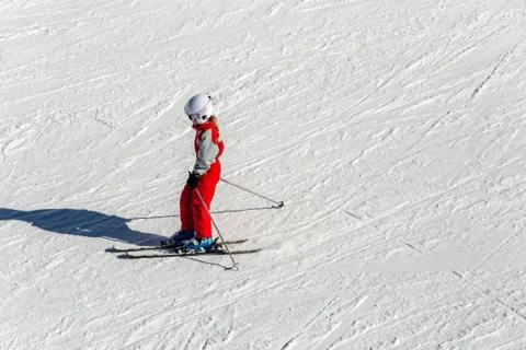 Child skiing in mountains with safety helmet, goggles and poles Stock Photos