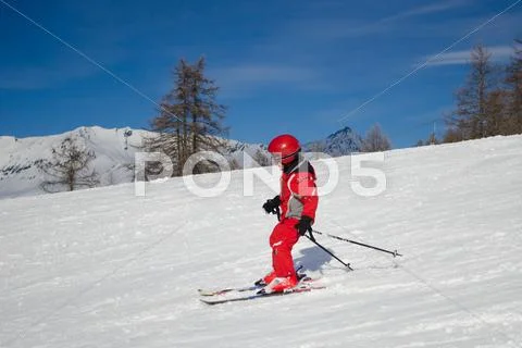 Child skiing in a sunny day Stock Photos
