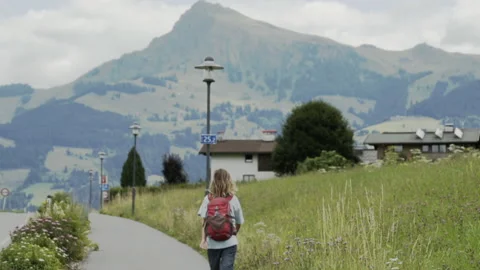 Child skips down sidewalk with mountain in background Stock Footage 148186402