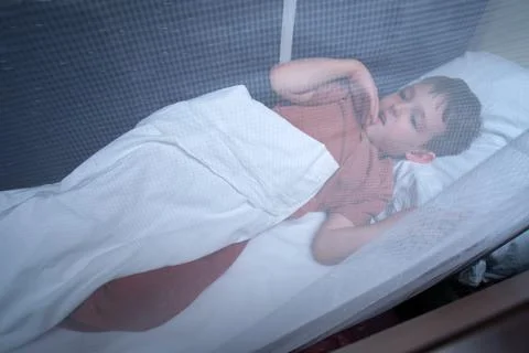 Child sleeping on a bunk bed in a train compartment. Little boy resting under Stock Photos