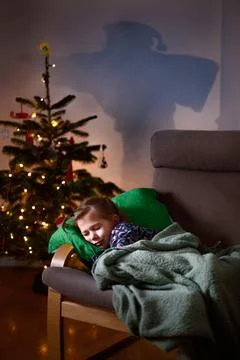 A child sleeping by the Christmas tree while Santa is coming Stock-Fotos