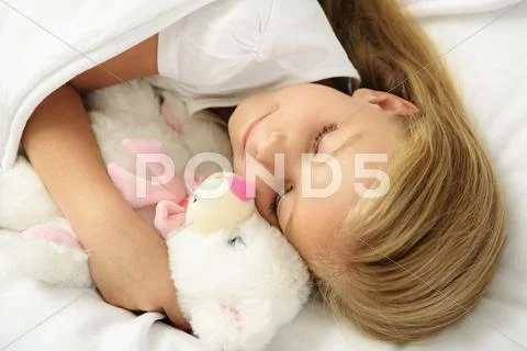Child sleeping on a couch with toy Stock Photos