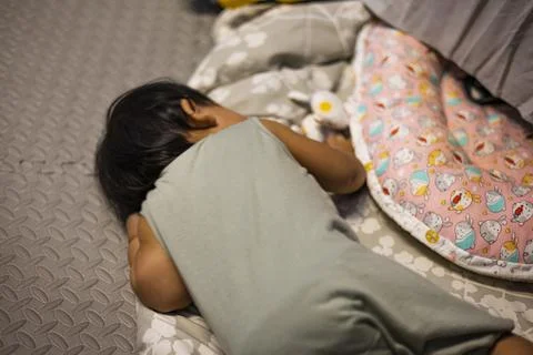 The Child Is Sleeping On Ground Stock Photos