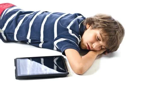 Child sleeping next to tablet pc Stock Photos