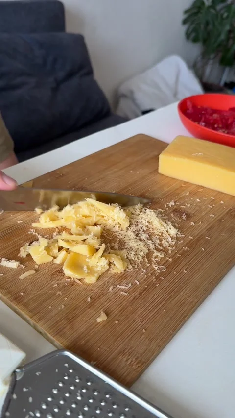 Child slicing block of cheese with knife, close-up hands, part of cheese and Stock Footage 337362323