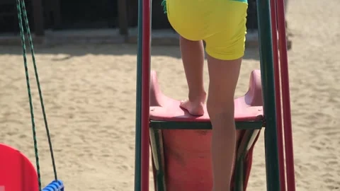 A child slides down a slide on the beach. Stock Footage 255924662