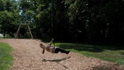 Child sliding fast on a zip line attraction at a public park playground Stockbeeldmateriaal 337290169