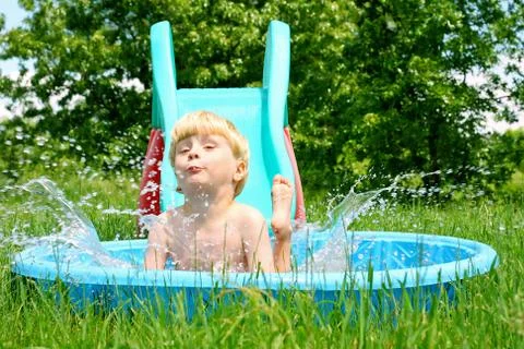 Child sliding into pool Stock Photos