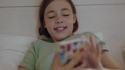 Child with smartphone before bedtime.	 Video stock 311806120